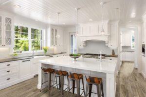 Kitchen tiles being used on the floor and backsplash in a white kitchen with an island and bright lights