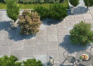 Outdoor tie on a patio with furniture, plants and bushes.